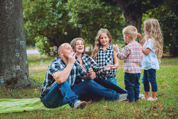 Fototapeta premium Young family with cheerful children in the park