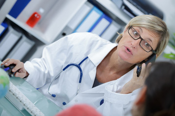 confident female doctor talking on the phone with patient