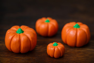Little polymer clay pumpkins on dark wooden background
