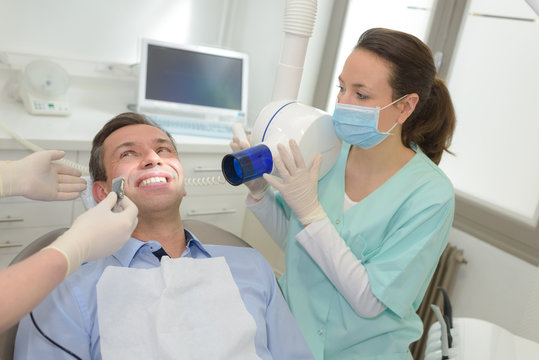 female dentists working on young male patient dentists office