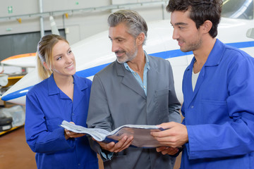 Students and teacher looking at manual