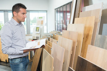 man choosing wood panels in store