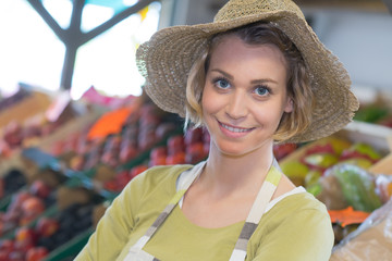 smiling female staff in organic section of supermarket