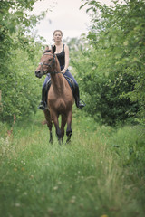 Young woman ridding on a horse