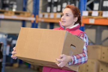 nice young woman carrying box