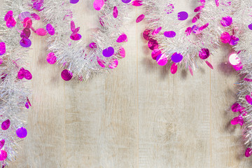 Christmas tinsel on the background of wooden boards