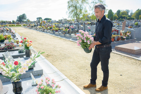 Man holding flowers to place on grave