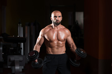 Fototapeta na wymiar Man With Dumbbells Exercising Biceps