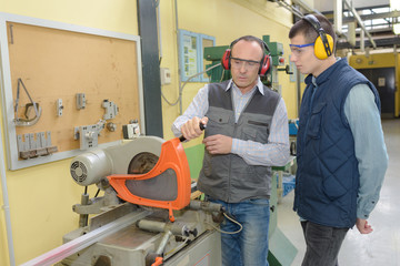 carpenter and apprentice using circular saw