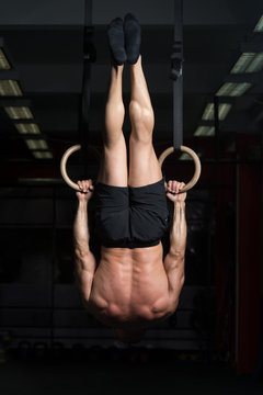 Muscular Athlete Hanging On Gymnastic Rings