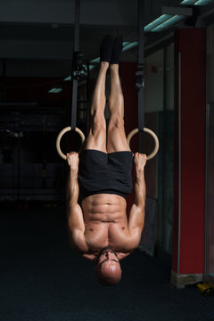 Muscular Athlete Hanging On Gymnastic Rings