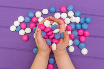 Children's hands holding colored candies