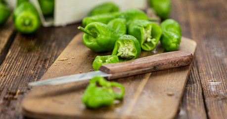 Portion of Raw Pimientos on wooden background, selective focus