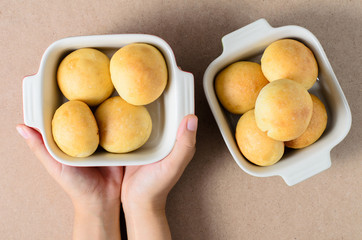Homemade buns in a bowl holding by hand,bread and bakery.Top view of food