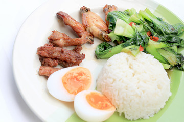 stir fried vegetables, Hard-boiled egg, Fried pork and Fried chicken wings with thai jasmine rice on dish. Thai food.