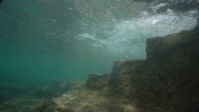 Old stone stairs under water. Waves fall into the water. Beautiful view 