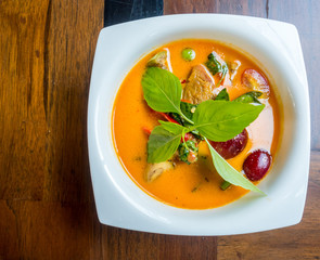 Thai duck curry soup in white bowl,