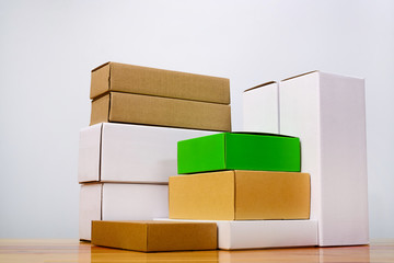 Group of cardboard box different color and size, pile of package made from paper for mock-up on wooden table with copy space.