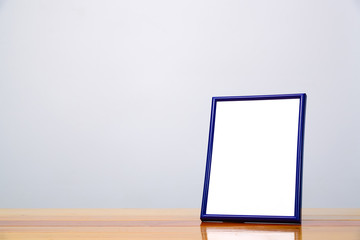 Empty blue photo frame on wooden table with copy space, picture memory.