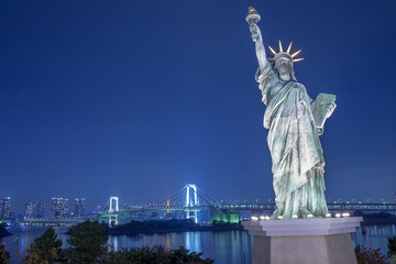 Fototapeta premium Statue of Liberty and Rainbow bridge at Odaiba Tokyo in twilight