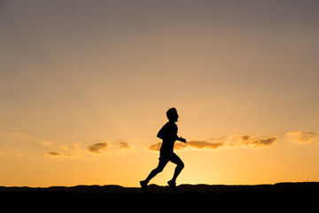 Silhouette of a man running at sunset