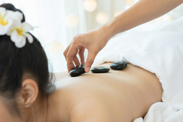 Young beautiful woman getting hot stone spa treatment.