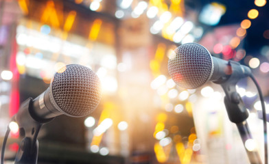 Microphones on stage in concert on lighting background
