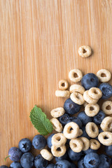 Fresh healthy berries of blueberries with dietary snack and mint leaves on wooden board