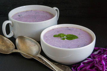 Soup of red cabbage on a black background.