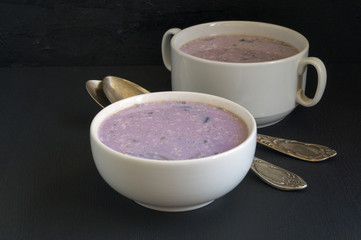 Soup of red cabbage on a black background.