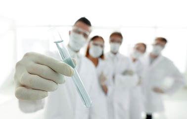 background image is a group of medical workers working with liquids in laboratory