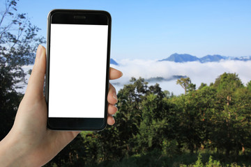  Hipster hand holding mockup mobile smart phone with white blank screen on background blur high mountain and sea of mist.