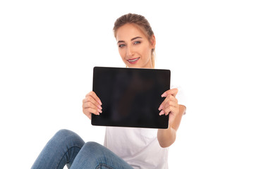 happy casual woman showing the blank screen of a tablet
