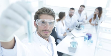 tube with reagents on blurred background laboratory.