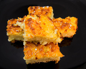 Baked rice pudding dessert sweetened with sugar powder on black dish. for food concept