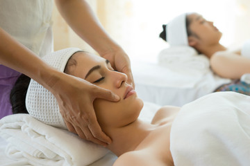Fototapeta na wymiar Young beautiful woman having face massage relaxing in spa.