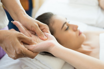 Young woman receiving hand massage in spa.