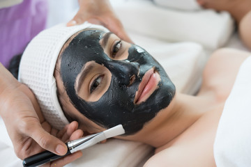 Beautiful woman getting facial mask at beauty salon.