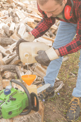 Winter is coming - lumberjack maintaining chainsaw outdoors.