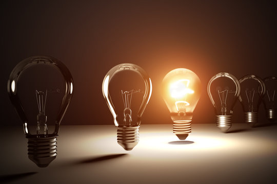 A row of light bulbs. One is glowing. 3D rendered illustration.