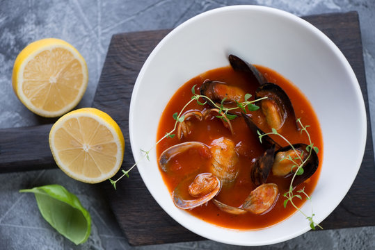 Plate of tomato soup with vongole clams and mussels, view from above