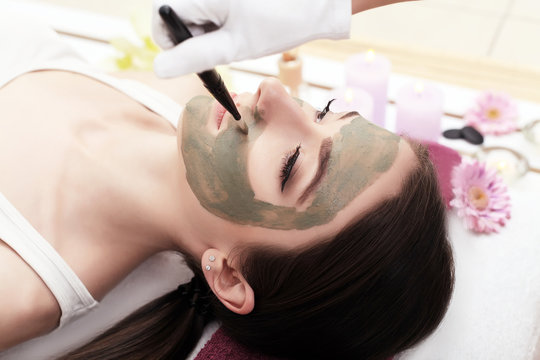 Spa therapy for young woman having facial mask at beauty salon