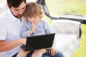 Father teaching his daughter using laptop computer.