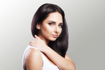Naklejka premium Shoulder pain. The woman holds two hands over the neck and shoulders. Dislocation. Cold. Muscle tension The concept of health. On a gray background.