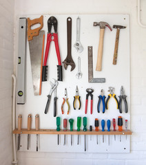 Assorted tools on a white tool board