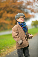 Cute stylish boy in warm clothes in autumn scenery
