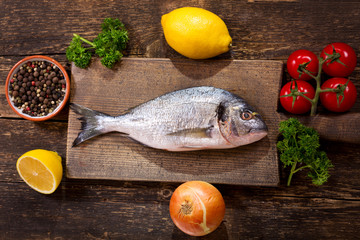 fresh fish dorado with ingredients for cooking