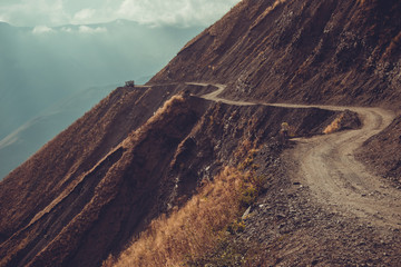 Spectacular and dangerous mountain road, Tusheti, Georgia. Adventure concept. Mount landscape. Unpaved winding road. Dirt serpentine road. Explore the world. Travel to Caucasus. Impressive view.