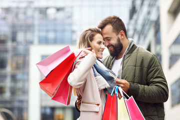 Happy couple shopping in the city