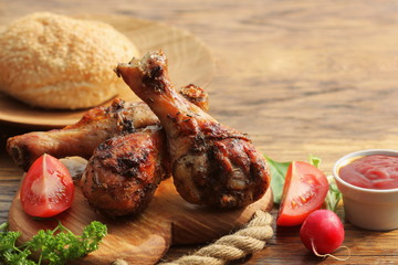 Grilled chicken legs on cutting board.Rustic dinner background